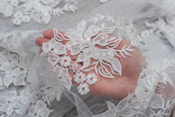 White wooden background with white spring flowers roses and lace ribbon. Happy womans day. The texture of lace on wooden background.