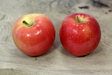 Two red apples on board. Focus on apples.