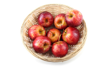Red little apples on wicker plate