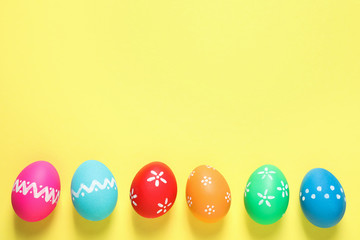 Fototapeta na wymiar Colorful Easter eggs on yellow background, flat lay. Space for text