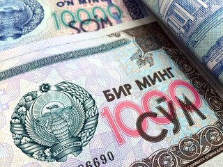 Uzbek money closeup. The 1000 Uzbekistani som (UZS) banknote carries the national emblem of Uzbekistan. 