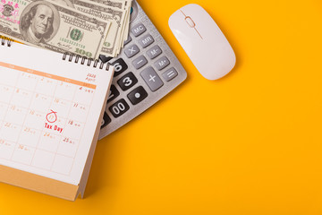 Tax Day, Top view flat lay closeup calculator, laptop computer, calendar, and Dollar money