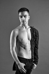 Fototapeta premium Sexy young man posing in studio. Gray background