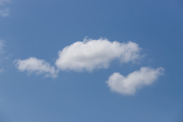 Fluffy three clouds a blue sky.