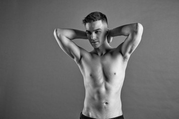 Obraz premium Sexy young man posing in studio. Gray background
