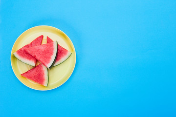 Obraz na płótnie Canvas slices of ripe watermelon on yellow plate