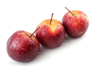 Three wet red little apples