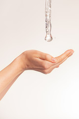 Photo of women's hands on which a stream of clean water pours. Human hands with falling water and...
