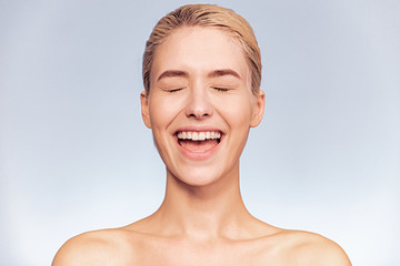 Frontal portrait of a girl with closed eyes and open mouth. Face close-up of a blonde screaming...