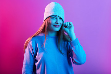 Close up portrait of screaming young woman with knitted cap covering her eyes isolated over pink...