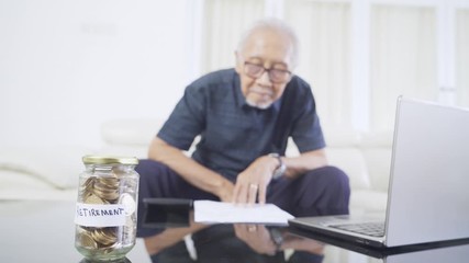 Money box with old man working background