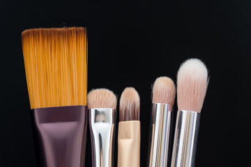 Set of makeup brushes on black background view