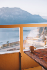 table with hot coffee and chairs on the terrace overlooking the lake and mountains