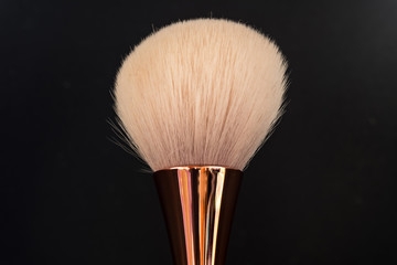 single makeup brush on black background macro view