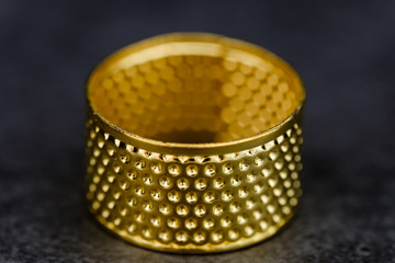 gold thimble closeup detail view on black background