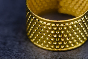 gold thimble closeup detail view on black background
