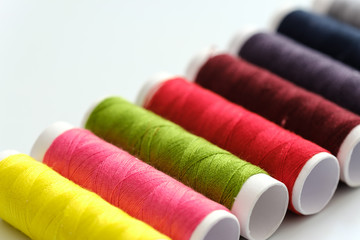 Close up macro view of colorful yarn reels on white background