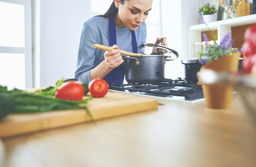 Cooking woman in kitchen with wooden spoon