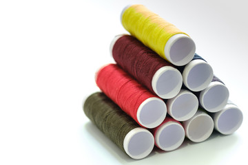 Close up macro view of colorful yarn reels on white background