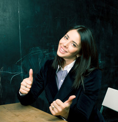 portrait of happy cute student at blackboard in classroom smiling