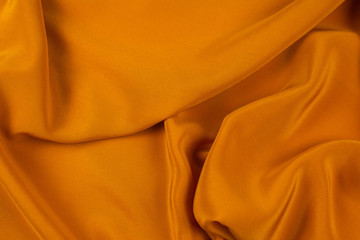 Golden silk or satin luxury fabric texture can use as abstract background.