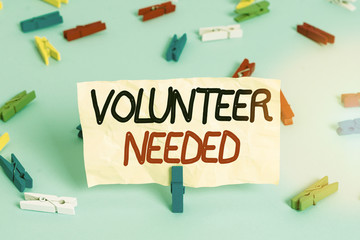 Text sign showing Volunteer Needed. Business photo showcasing asking demonstrating to work for organization without being paid Colored clothespin papers empty reminder blue floor background office pin