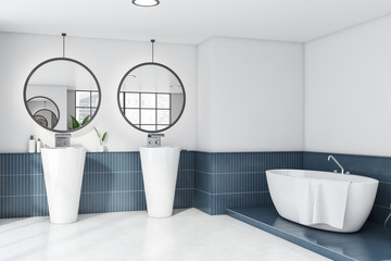 White and blue bathroom corner double sink and tub