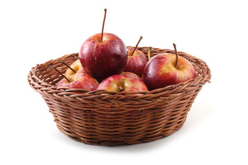 Red little apples on wicker plate