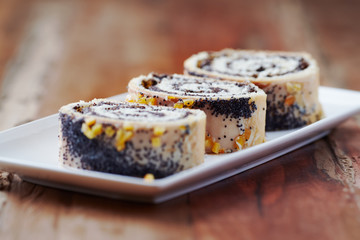 Poppy seed roll on wooden background. Close up.