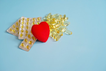 Omega 3 capsules with red heart. Fish oil in tablets. Health support and heart treatment....