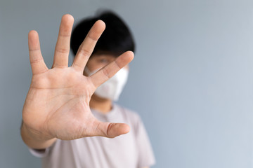 closeup men wearing a mask to protect the coronavirus (COVID-19) and PM2.5 dust with showing palm hand. soft-focus and over light in the background