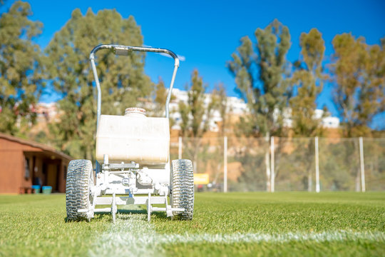drawn white lines on the football field with white paint on the grass using a special machine before a game