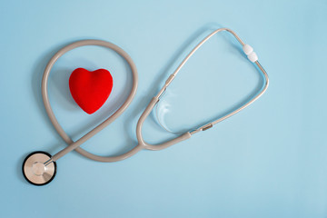 Stethoscope and red heart on a blue background. Cardiology and heart health concept. The medicine....