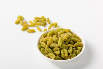 The green raisins dry in the sun and stand alone on a white background