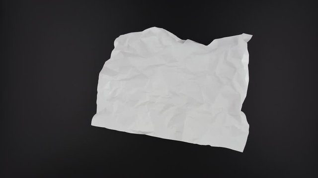 Stop motion VDO, paper ball unwrapping on black background.