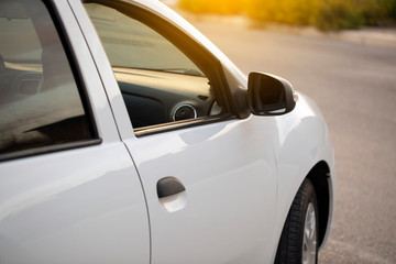 Fototapeta na wymiar White economy sedan car detail view at sunset