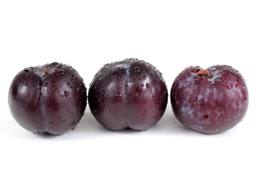 Three wet black plums