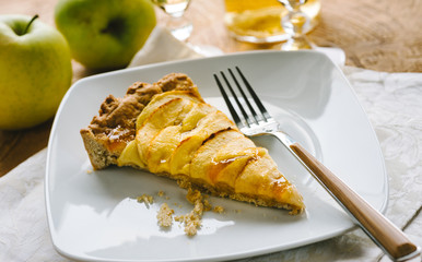 A slice of homemade apple tart on white plate