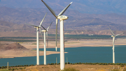 Windmills by the lake with beautiful background of blue sky and white cloud.