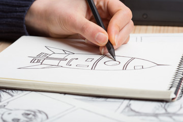 Artist drawing an anime comic book in a studio. Wooden desk, natural light. Creativity and...