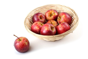 Red little apples on wicker plate