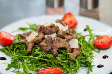 Tasty and juicy grilled meat with arugula, cheese, tomato sauce and spices