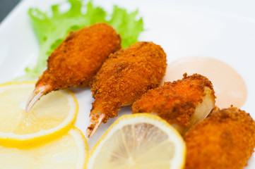 Crab claws fried in batter with lemon, lettuce and tasty sweet and sour sauce