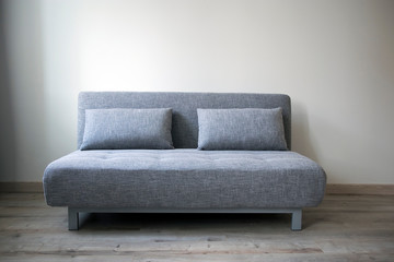 Copy space. Gray sofa with pillows in the style of the sixties in the interior.