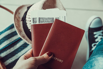 Woman holding passport with boarding pass close up at airport