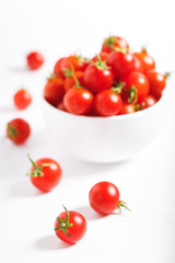 red cherry tomato in  ceramic bowl on white background