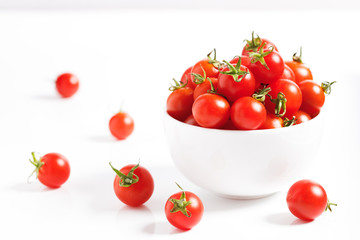 red cherry tomato in  ceramic bowl on white background