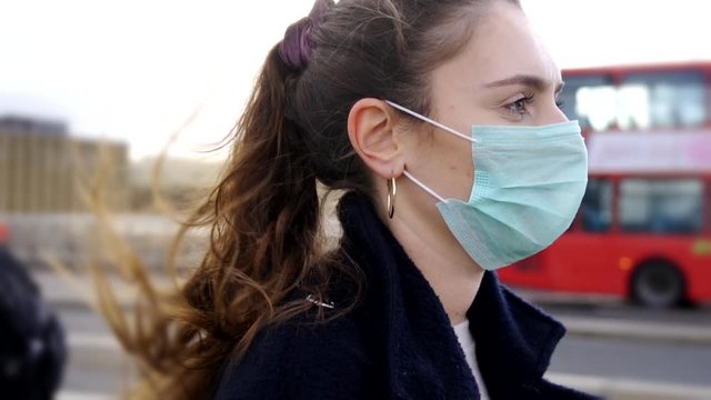 Profile of Young woman wearing face mask while walking in the streets of London