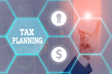 Writing note showing Tax Planning. Business concept for man of financial situation or plan from a tax perspective