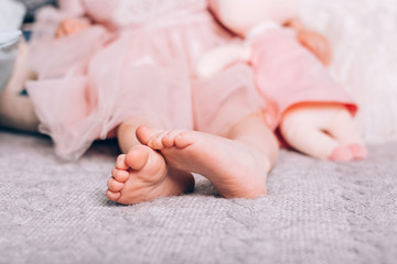 Cute little childs's bare feet lying on warm knitted blanket with soft toy. Cozy time at home, lifestyle.